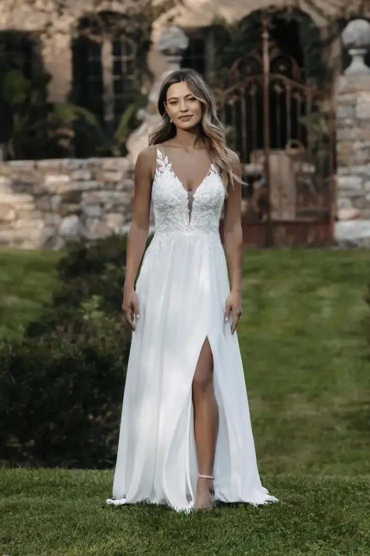 Model is wearing an a-line wedding dress with lace appliques and illusion netting by allure romance