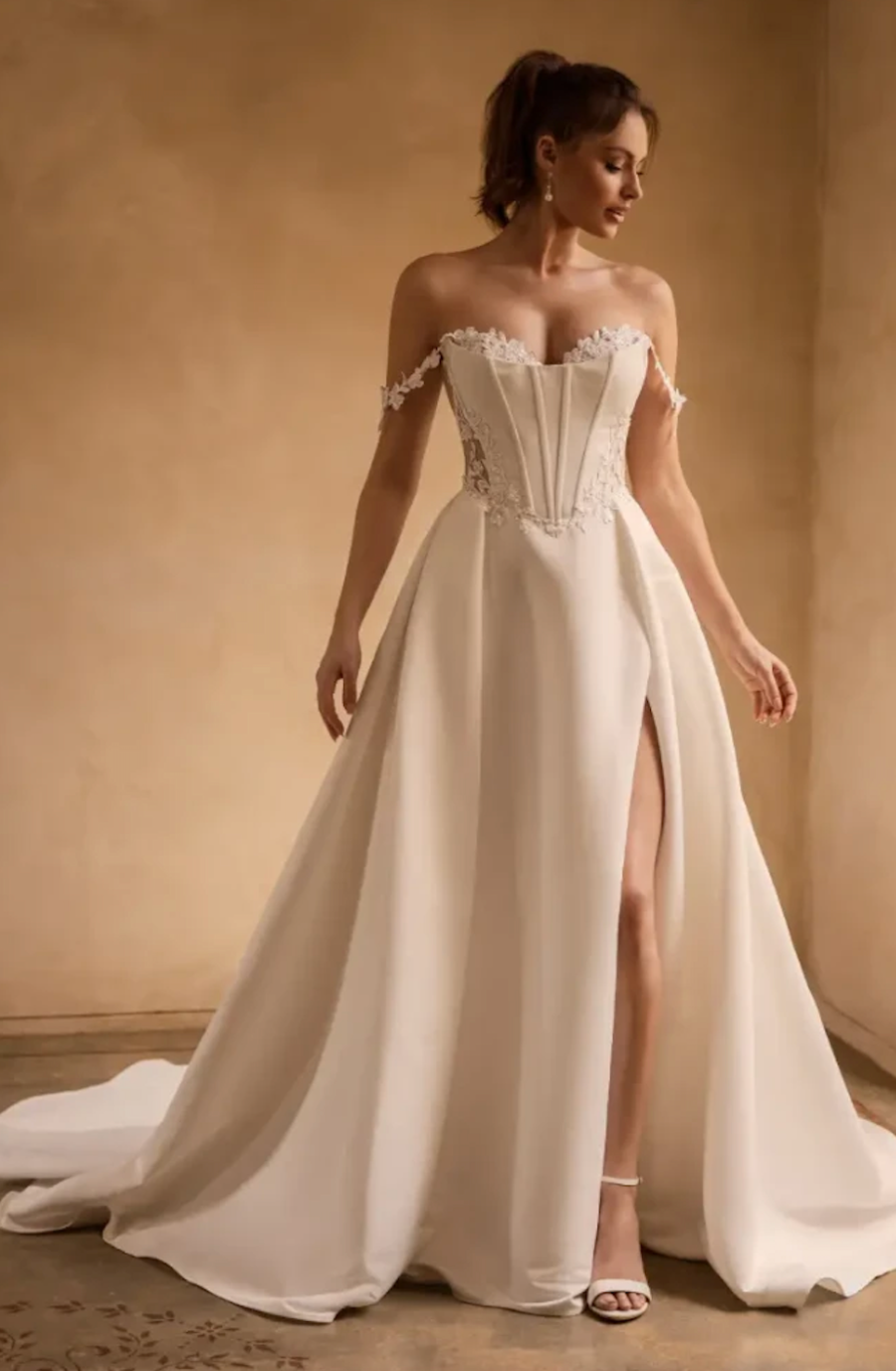 model is wearing an off the shoulder a-line corset bridal gown